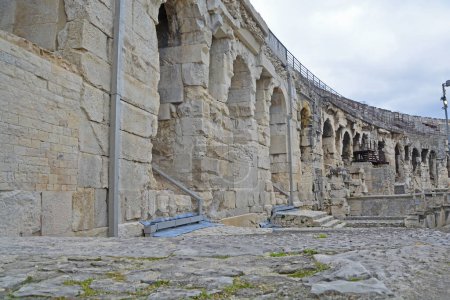 Téléchargez les photos : A l'intérieur d'un ancien amphithéâtre romain à Nîmes dans le sud de la France avec de hauts couloirs voûtés menant aux sièges. L'un des amphithéâtres les mieux conservés au monde - en image libre de droit