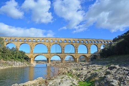 Foto de El antiguo puente romano del acueducto de Gard y el puente del viaducto sobre el río Gardon, el más alto de todos los antiguos puentes romanos, cerca de Nimes en el sur de Francia - Imagen libre de derechos