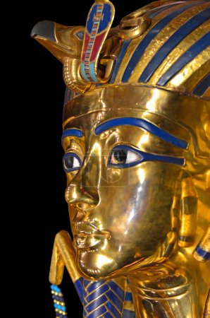 Foto de Primer plano de la máscara de la muerte del faraón egipcio Tutankamón. Ejecutado en oro y lapislázuli. Aislado sobre un fondo negro. - Imagen libre de derechos