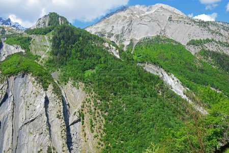 Foto de Una casa remota al lado de una montaña muy alta en los Alpes suizos. El Haut du Cry en los Alpes suizos del sur sobre el valle del Derborance - Imagen libre de derechos