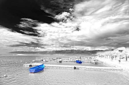 Téléchargez les photos : Monochrome de bateaux de pêche traditionnels sous des nuages intéressants dans la mer Adriatique - en image libre de droit