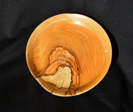 Photo for Olive bowl decoration turned manually from olive tree wood, against a black cloth - Royalty Free Image
