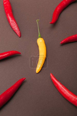 Photo for Red and yellow chili peppers on brown background - Royalty Free Image