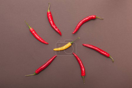 red and yellow chili peppers on brown background