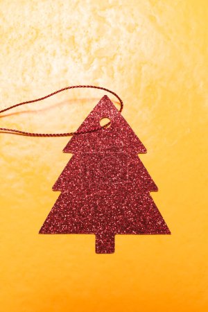 Foto de Adorno de árbol de Navidad rojo sobre fondo amarillo - Imagen libre de derechos