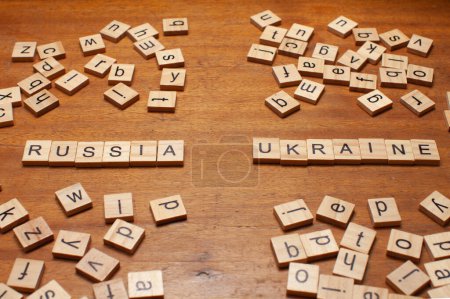 russia and ukraine letters on wooden background