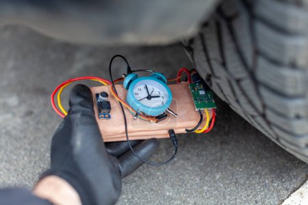 Foto de Mafioso colocando una bomba de tiempo debajo del vehículo - Imagen libre de derechos