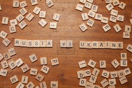 Russland vs Ukraine Buchstaben auf hölzernem Hintergrund