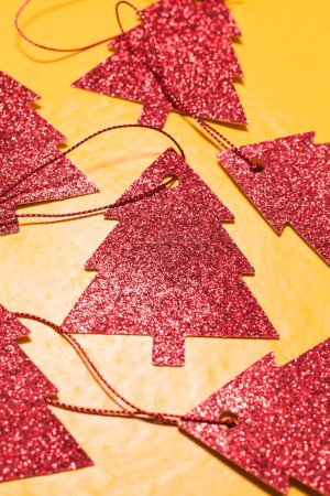 Photo for Red christmas tree ornaments on yellow background - Royalty Free Image