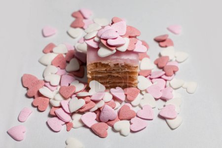 pequeño pastel espolvoreado con cuentas de azúcar decorativas en forma de corazón