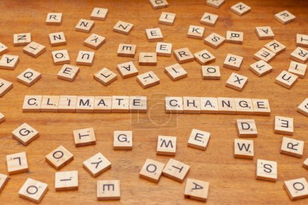 Téléchargez les photos : Carreaux lettre changement climatique disposés sur fond de panneau en bois - en image libre de droit