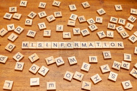 misinformation letters arranged on wooden board background