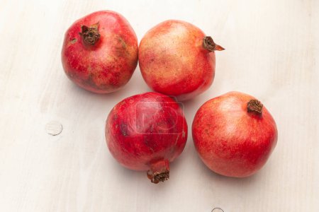 Photo for Many pomegranates fruits arranged on light wooden background - Royalty Free Image