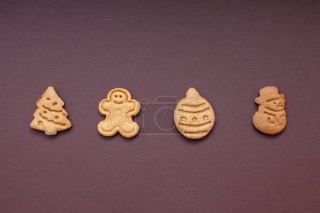 Téléchargez les photos : Biscuits en forme de Noël isolés sur fond brun - en image libre de droit