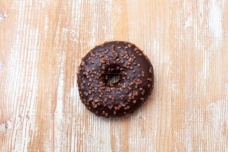 Photo for Chocolate doughnut isolated on light wooden background - Royalty Free Image