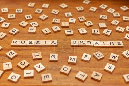 russia and ukraine letters on wooden background