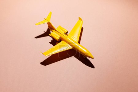 Téléchargez les photos : Avion jouet jaune foncé sur fond rose - en image libre de droit