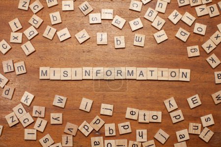 Photo for Misinformation letters arranged on wooden board background - Royalty Free Image