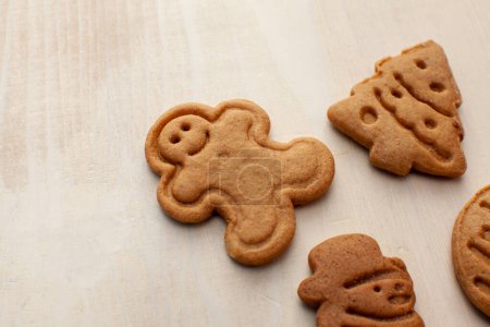Téléchargez les photos : Biscuits en forme de Noël isolés sur fond de bois blanc - en image libre de droit
