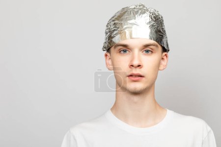 Photo for Portrait of young man wearing tin foil hat. Conspiracy theories and paranoya concept. Studio shot on gray background - Royalty Free Image