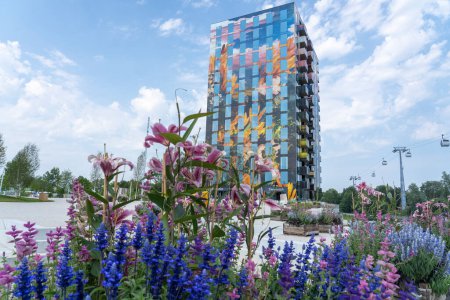 Téléchargez les photos : Next to the colorful apartment building is a monorail and in the foreground a flower box with lilies and Salvia, at a horticultural exhibition in Almere, the Netherlands - en image libre de droit