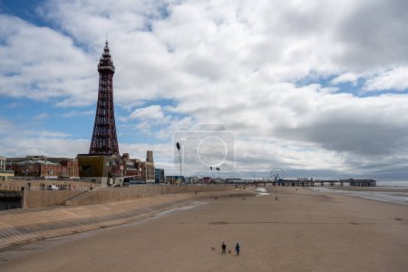 Téléchargez les photos : BLACKPOOL 1er MAI 2023 : Tour mondialement connue de Blackpool et touristes et excursions d'une journée sur la plage en face de lui, vue de la jetée Nord. - en image libre de droit
