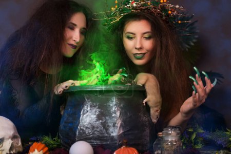 Two witches with tousled hair brew a potion in a cauldron with rats, halloween concept.
