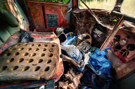 Foto de Interior de un coche viejo abandonado. La cabina descuidada de un vehículo pesado. Basura y telarañas en el interior oxidado de un coche viejo. - Imagen libre de derechos