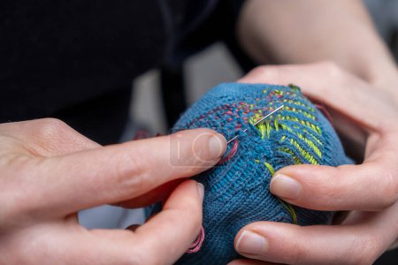 Photo for Mending clothes. Visible mending repairing sock. Darning old socks, reducing waste, slow fashion. Repair concept, selective focus. - Royalty Free Image