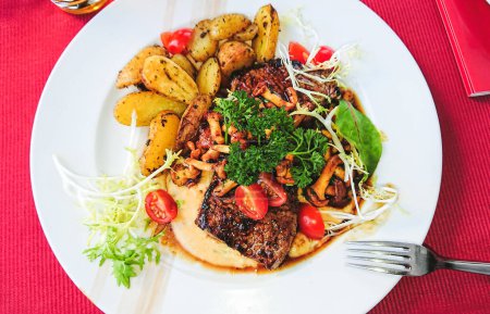 Téléchargez les photos : Steak de bœuf grillé aux girolles et légumes dans une assiette, vue sur le dessus - en image libre de droit