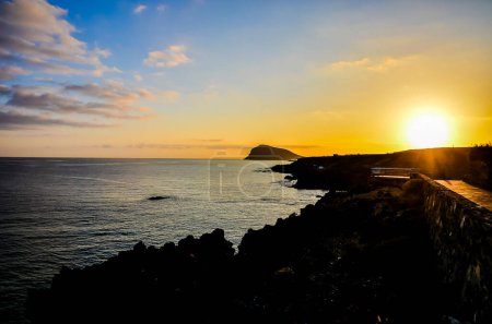 Salida del sol en el Océano Atlántico con una montaña en segundo plano El Medano Tenerife Islas Canarias España
