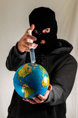Hombre joven vestido negro sosteniendo una tierra globo