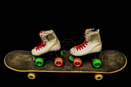 Schwarzes Skateboard und Skate-Boot im Vintage-Stil auf dunklem Hintergrund