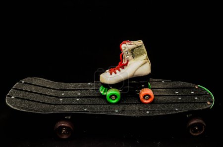 Schwarzes Skateboard und Skate-Boot im Vintage-Stil auf dunklem Hintergrund