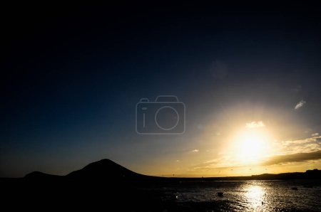 Puesta de sol en el Océano Atlántico con una montaña en segundo plano El Medano Tenerife Islas Canarias España