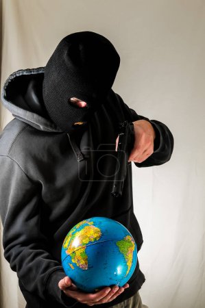 Schwarz gekleideter junger Mann hält eine Erdkugel in der Hand