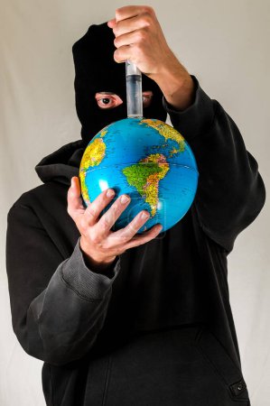 Hombre joven vestido negro sosteniendo una tierra globo