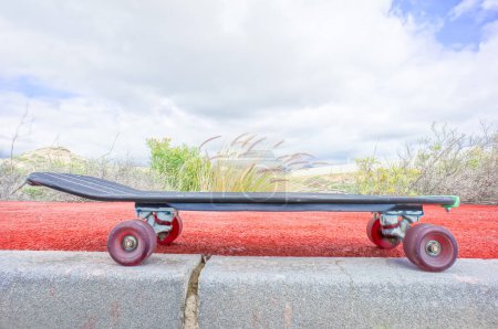 Estilo Vintage Longboard Black Skateboard en un camino vacío del desierto de asfalto