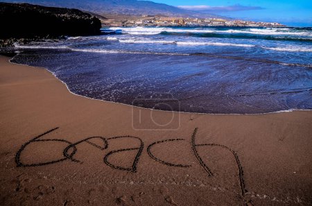 Auf den Sand eines tropischen Strandes geschriebenes Wort