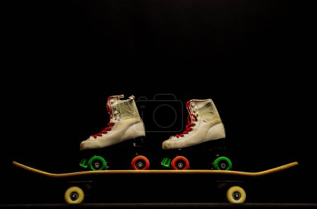 Two pairs of roller skates are on a skateboard