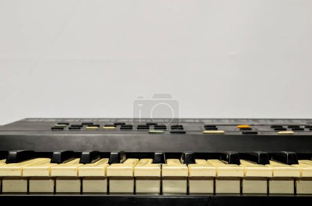 Teclado blanco y negro con teclas blancas. El teclado es viejo y tiene un aspecto vintage