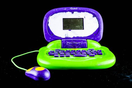 A green and purple laptop with a mouse on it