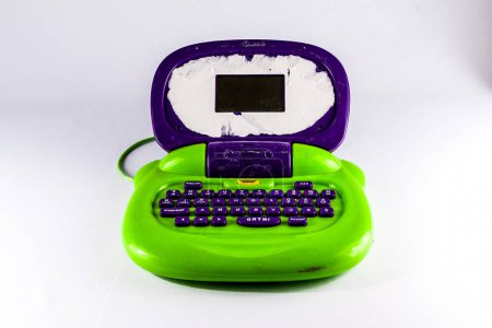 A green and purple laptop with a keyboard. The laptop is on a white background