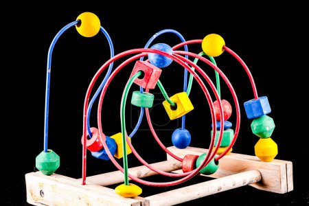A wooden toy with colorful beads and a red and green circle
