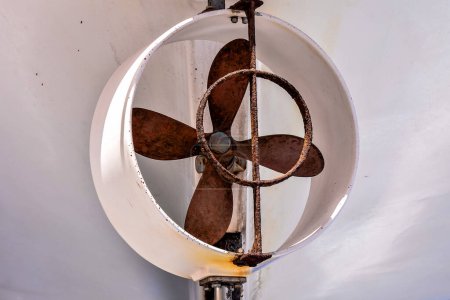 Ein Ventilator mit einer rostigen Klinge hängt von der Decke. Der Ventilator ist alt und verrostet und in keinem guten Zustand.