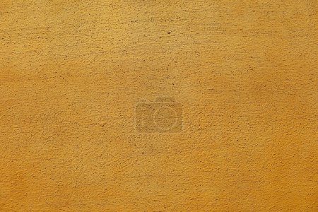 Téléchargez les photos : Une photo en gros plan pour le fond sur un mur jaune vif exposé au soleil du début de l'été - en image libre de droit