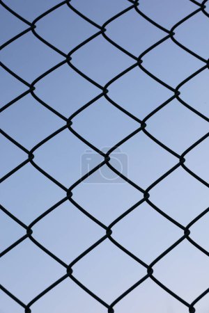 A wire fence silhouetted against a clear sky