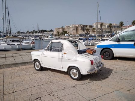 A very small original beautiful car on the shore of the harbor of Cascais (Portugal).