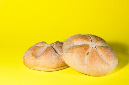 Téléchargez les photos : Two round breads fresh from oven on a yellow background. - en image libre de droit