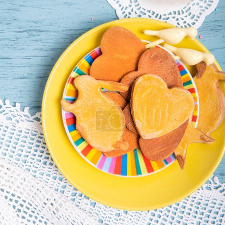 Téléchargez les photos : Biscuits faits maison sur une assiette jaune avec nappe en dentelle tricotée sur une table de cuisine, vue sur le dessus - en image libre de droit